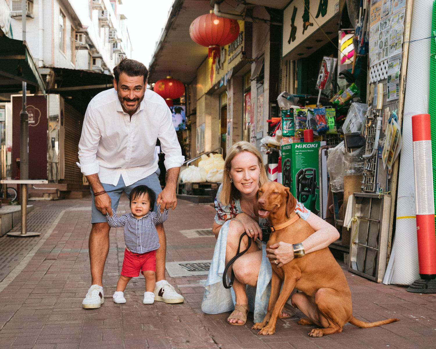 family with infant son and large brown dog in a busy lane street of Sai Kung, Hong Kong