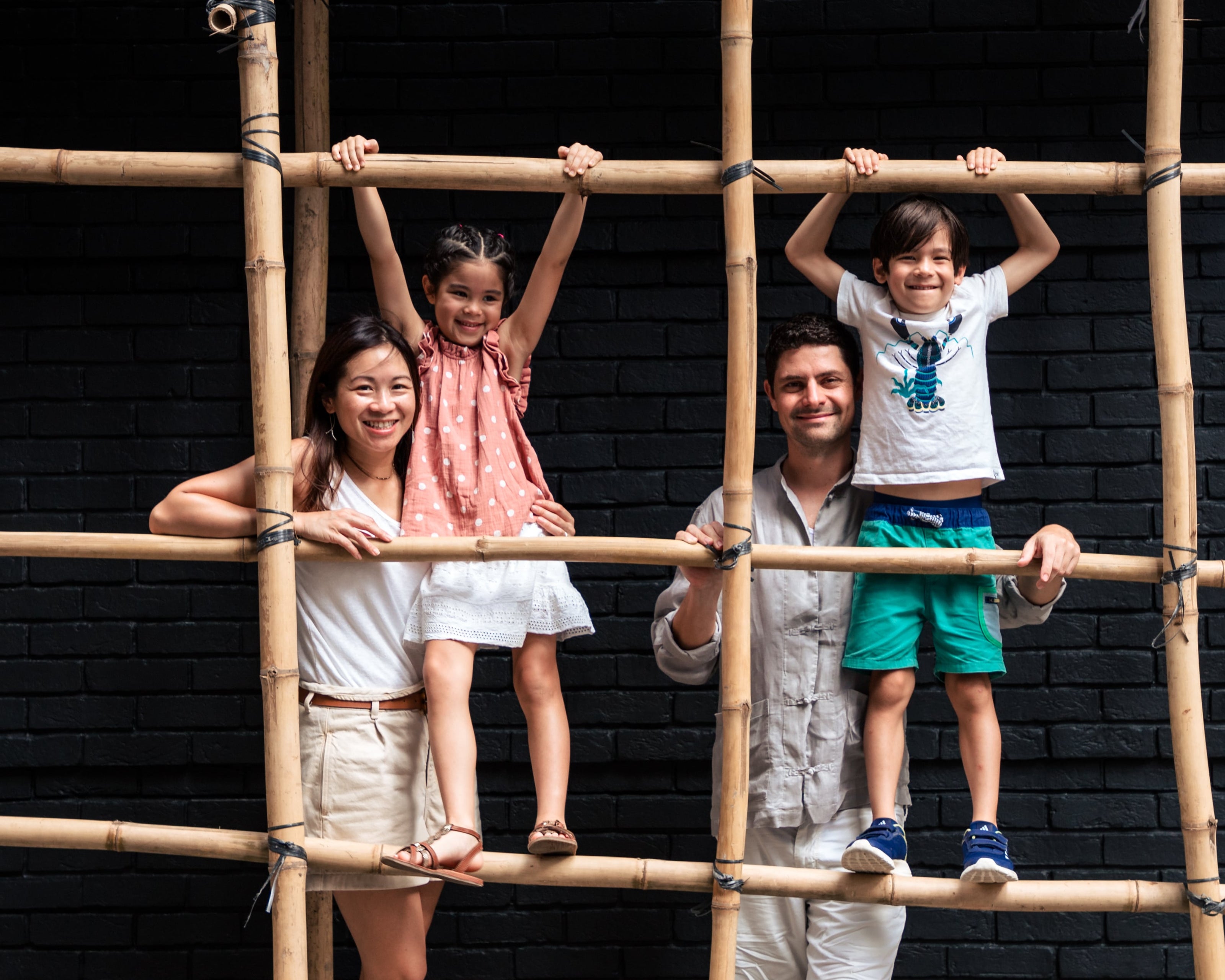 Family of four on bamboo scaffolding for family photos  in hong Kong